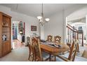 Elegant dining room featuring a classic chandelier, wood table, and staircase access at 5723 S Everett Way, Littleton, CO 80123