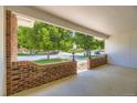 View of the street from the home's covered front porch with brick details at 649 Nucla Way, Aurora, CO 80011