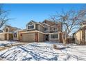 Two-story house with attached garage, brick accents, and snow-covered landscaping at 209 S Pembrook St, Castle Rock, CO 80104