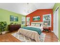 Bright primary bedroom features large windows, a vaulted ceiling, and a modern chandelier at 1241 S Akron Way, Denver, CO 80247