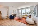 Bright living room with hardwood floors, large windows, stylish furniture, and modern decor at 10863 E Hinsdale Cir, Centennial, CO 80112
