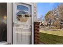 Close-up view of the front door with house number and decorative wreath on the screen door at 7309 W Hampden Ave # 6103, Lakewood, CO 80227