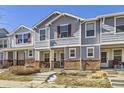 Gray townhome with brick accents and a charming front porch at 5833 N Biscay St, Denver, CO 80249