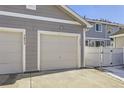 Two-car garage with attached driveway and fence at 5833 N Biscay St, Denver, CO 80249