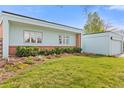 Charming single story home exterior with a lush green lawn and beautiful garden beds at 1420 E Bates Ave, Englewood, CO 80113