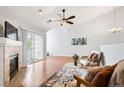 Bright living room with fireplace, ceiling fan, and sliding door access to the balcony at 3242 E 103Rd Dr # 602, Thornton, CO 80229