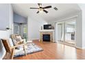 Bright living room with fireplace, ceiling fan, and sliding door access to the balcony at 3242 E 103Rd Dr # 602, Thornton, CO 80229
