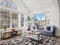Well-lit living room featuring a gray couch, large windows, and a modern rug at 6755 S Ivy St # A7, Centennial, CO 80112