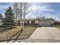 Classic ranch style home featuring a front porch, two-car garage, and mature trees at 9256 W Euclid Ave, Littleton, CO 80123