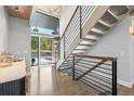 Bright foyer with modern staircase, chandelier, and natural light streaming through the glass front door for an inviting entrance at 347 S White Tail Dr, Franktown, CO 80116