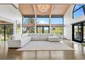 Expansive living room with vaulted ceilings, large windows, and a stylish white sofa, creating a bright and airy space at 347 S White Tail Dr, Franktown, CO 80116