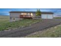 Gray single-story house with deck and lawn at 11100 Haskell Creek Rd, Larkspur, CO 80118