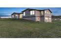 Gray two-story house with lawn and blue sky at 11100 Haskell Creek Rd, Larkspur, CO 80118