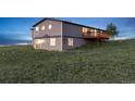 Rear view of gray two-story house with walkout basement and deck at 11100 Haskell Creek Rd, Larkspur, CO 80118