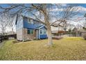 Spacious backyard with a wooden deck, mature trees, and a well-maintained lawn at 12842 Bellaire St, Thornton, CO 80241