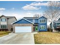 Beautiful two-story house with a well-maintained front lawn, blue siding, and brick detail at 12842 Bellaire St, Thornton, CO 80241