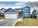 Attractive two-story home featuring blue siding, brick accents, and an attached two-car garage at 12842 Bellaire St, Thornton, CO 80241