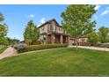 Charming two-story home with a lush green lawn, mature trees, and well-manicured landscaping at 30 S Ider Way, Aurora, CO 80018