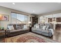Comfortable living room with plush seating, a large window, and an open layout to the kitchen at 30 S Ider Way, Aurora, CO 80018