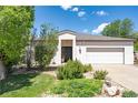 Attractive single-story home featuring a well-manicured front yard, mature trees, and an attached two-car garage at 330 Ptarmigan St, Golden, CO 80403