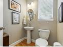 Stylish powder room features a pedestal sink, round mirror, and framed artwork at 3240 Spruce St, Denver, CO 80238