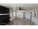 Bright living room boasts a decorative fireplace, sleek ceiling fan and new wood-style flooring at 15600 E 33Rd Pl, Aurora, CO 80011