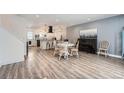 Open-concept dining area with a white round table, complementing chairs, a piano, and durable wood-look flooring at 1599 S Telluride St, Aurora, CO 80017