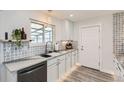 Bright kitchen featuring modern appliances, white cabinets, stainless steel dishwasher, and mosaic backsplash at 1599 S Telluride St, Aurora, CO 80017