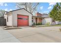 Exterior view of the home featuring a detached garage and driveway at 3198 W Amherst Ave, Denver, CO 80236