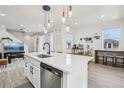 Open concept kitchen with large island, modern lighting, and adjoining dining area at 5388 Routt St # B, Arvada, CO 80002