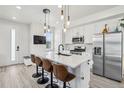 Bright kitchen with white cabinets, stainless appliances, and a large island with seating at 5388 Routt St # B, Arvada, CO 80002