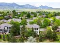 Scenic aerial shot showcases a home surrounded by mature trees in a peaceful neighborhood at 6032 Umber St, Arvada, CO 80403