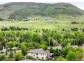 Picturesque aerial view of a home nestled amidst lush greenery and rolling hills at 6032 Umber St, Arvada, CO 80403