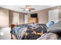 Comfortable bedroom featuring ceiling fan, dresser, and a black, white and gold comforter at 13664 Linden Ct, Thornton, CO 80602