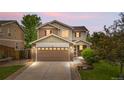 Charming two-story home with a two-car garage, stone accents, and manicured landscaping at 13664 Linden Ct, Thornton, CO 80602