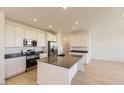 Modern kitchen featuring stainless steel appliances, kitchen island, and bright white cabinets at 6719 Juniper Dr, Thornton, CO 80602