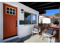 Inviting front porch with orange door and stylish seating at 3911 Vallejo St, Denver, CO 80211