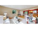 Open-concept living space with hardwood floors, leading to a modern kitchen and dining area at 6631 Welch Ct, Arvada, CO 80004