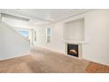 Bright living room with a cozy fireplace, carpet floors, and large windows offering natural light at 20108 Randolph Pl, Denver, CO 80249