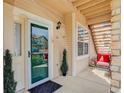 Inviting front porch with seating area, exterior door, and security system at 3993 S Dillon Way # 104, Aurora, CO 80014