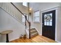 Elegant foyer showcasing a staircase with wooden accents, a stylish front door, and gleaming hardwood floors at 9445 E 106Th Pl, Commerce City, CO 80640