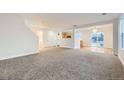 Open-concept living room featuring neutral carpet, bright white walls, and ample natural light at 11039 Columbine St, Northglenn, CO 80233