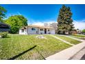 Landscaped front yard featuring a mature shade tree on a sunny day at 1183 S Umatilla St, Denver, CO 80223