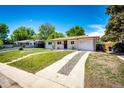 View of the front yard, driveway and single car garage of a charming house at 1183 S Umatilla St, Denver, CO 80223