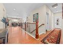 Bright foyer with hardwood floors, staircase with ornate railing, and views into a well-lit living room at 6420 Agave Ave, Castle Rock, CO 80108