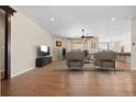 Open-concept living room with a large window, wood floors, and recessed lighting at 6420 Agave Ave, Castle Rock, CO 80108