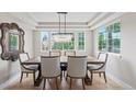 Chic dining room with elegant chandelier and large windows overlooking the backyard at 9432 La Quinta Way, Lone Tree, CO 80124