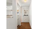 Open hallway with hardwood floors and a view into the kitchen beyond a decorative cutout at 945 Emerald St, Broomfield, CO 80020
