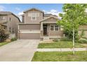 Charming two-story home with a two-car garage, inviting front porch with stone accents and landscaped front yard at 6484 N Ceylon Ct, Denver, CO 80249
