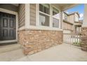 Close up of the front porch showcasing stone detail, dark door and well-maintained exterior at 6484 N Ceylon Ct, Denver, CO 80249